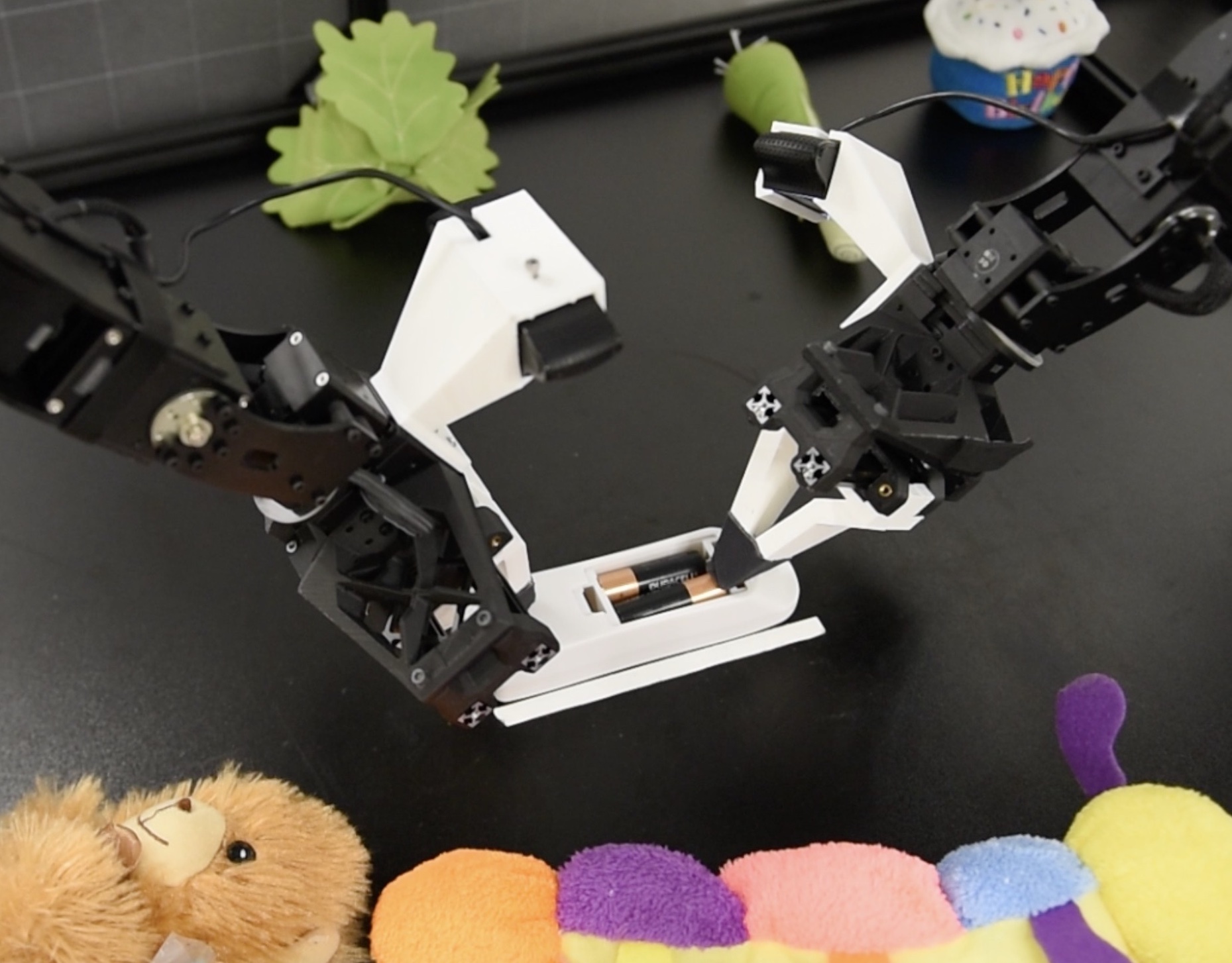 Two robot arms manipulating a battery
